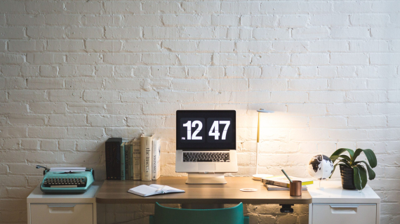 A clean and modern home office space with a laptop open on a minimalist desk setup